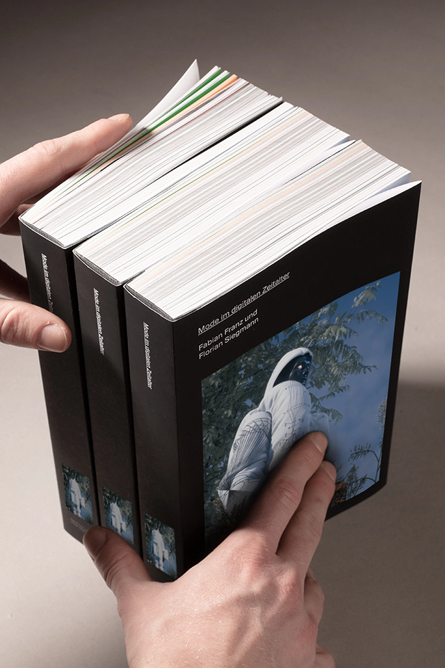 Photography of three books with a CGI image on the cover.